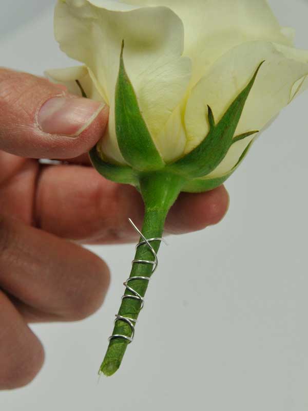foto5: En daarna weer terug van beneden naar boven zodat de uiteinden van het wikkeldraad een soort weerhaak vormen waarmee de bloem(en) achter de rubber afsluitring blijven hangen