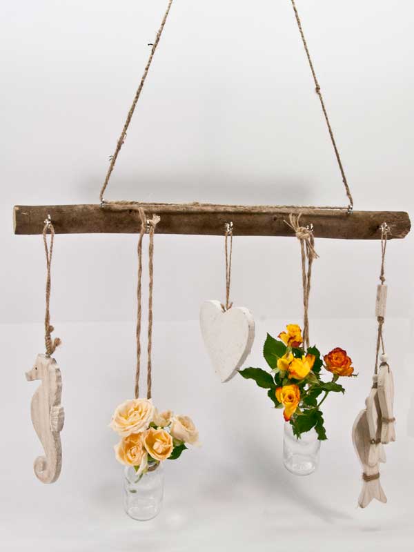 Decoratieve houten kapstok versierd met hangers en flesjes met bloemen